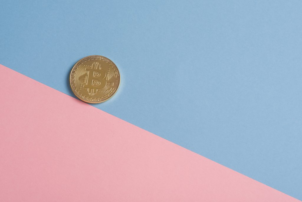 koin bitcoin dengan latar belakang biru muda dan merah jambu yang membantu pengguna memahami apa itu satoshi